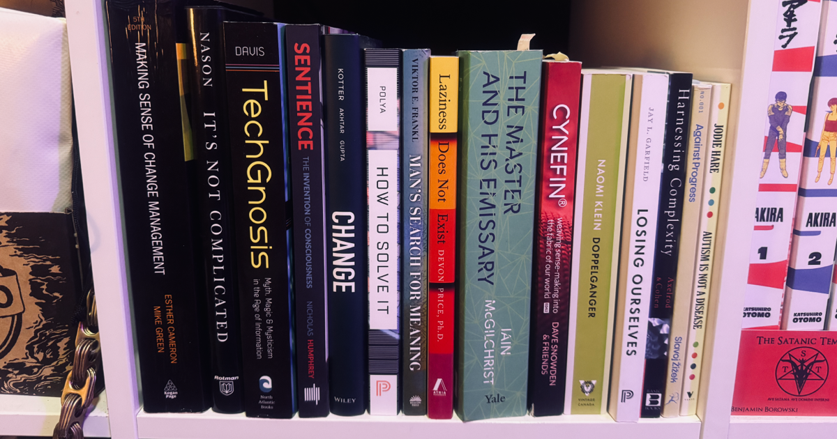 A photo of a bookshelf with the books listed in the article organized by book height.